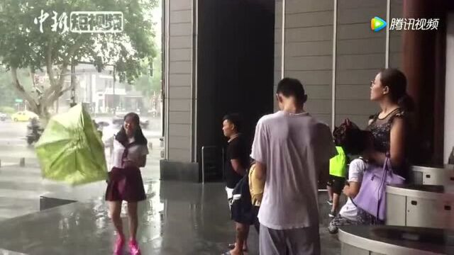 台风致江苏部分地区强降雨民众出行雨伞被掀翻