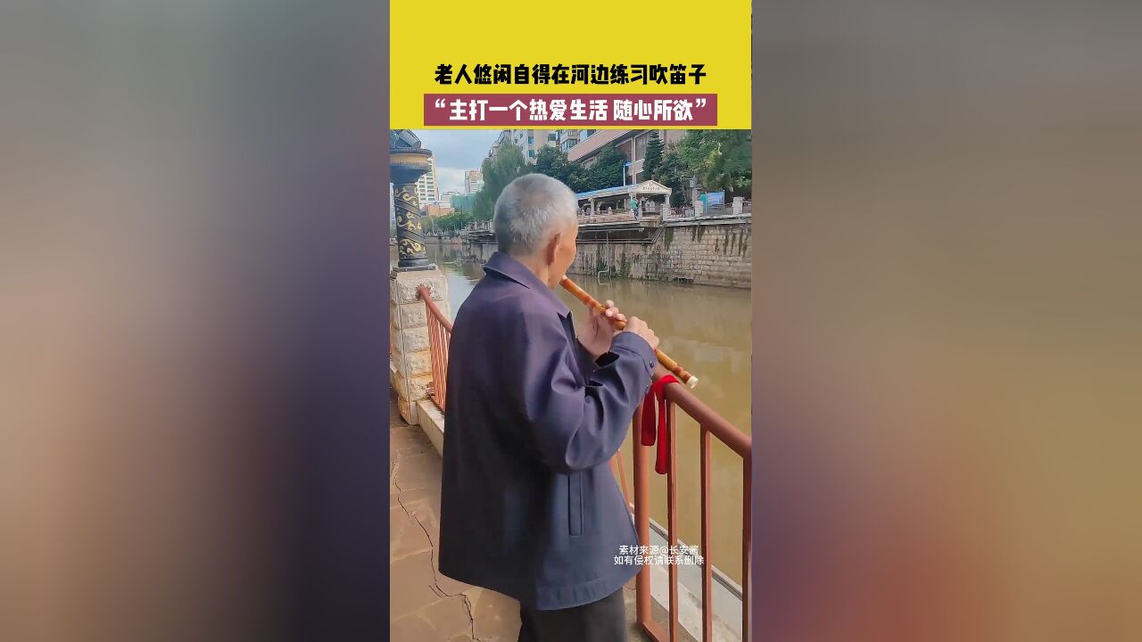 老人悠闲自得在河边练习吹笛子,主打一个热爱生活,随心所欲