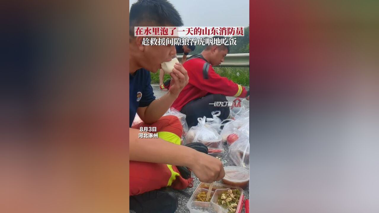 河北省保定市,消防员趁救援间隙坐在路边吃饭