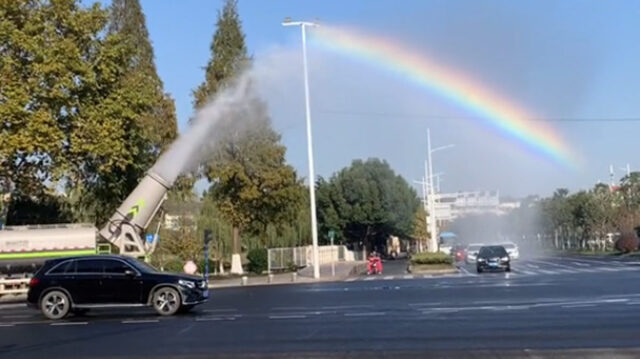 画面太治愈!洒水车化身"彩虹制造机,在路口上空画出一道彩虹