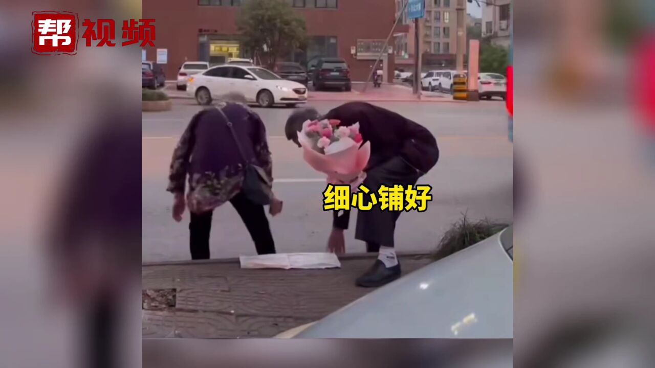 网友随手记录下老人手捧鲜花 和爱人一起等车