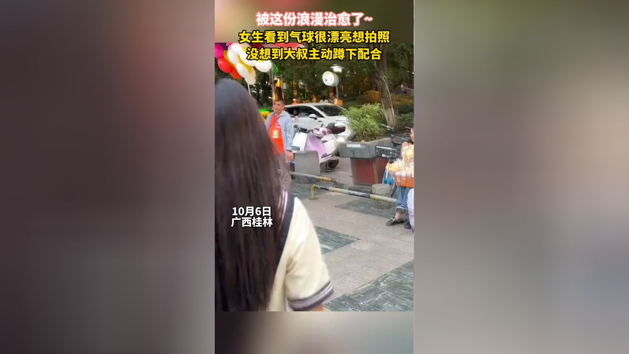 被这份浪漫治愈了~ 女生想和气球合影,卖气球的大叔立马蹲下充当背景墙