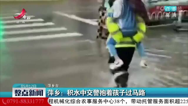 萍乡:积水中交警抱着孩子过马路