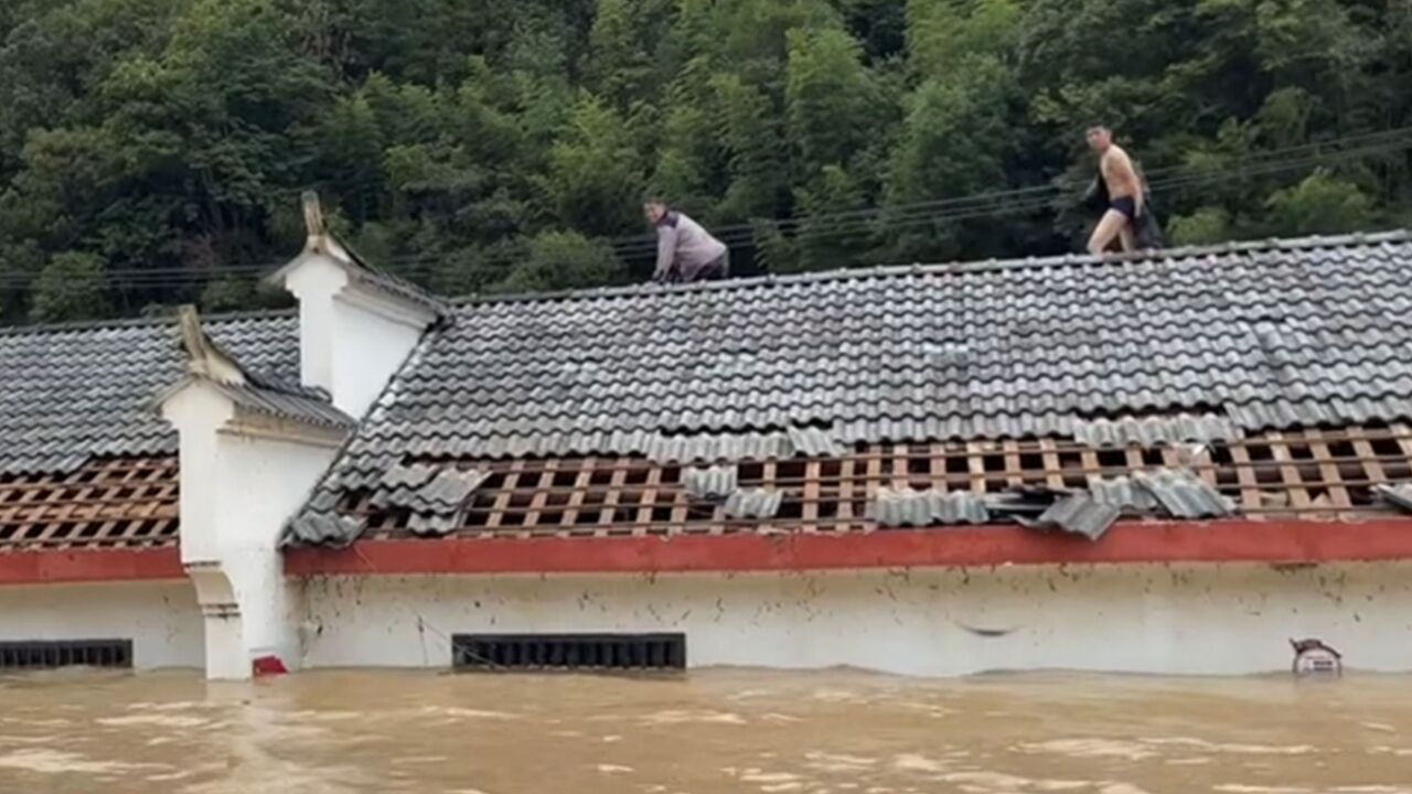 松滋遭暴雨袭击多个乡镇被淹,居民纷纷躲房顶,救援队沿途搜救