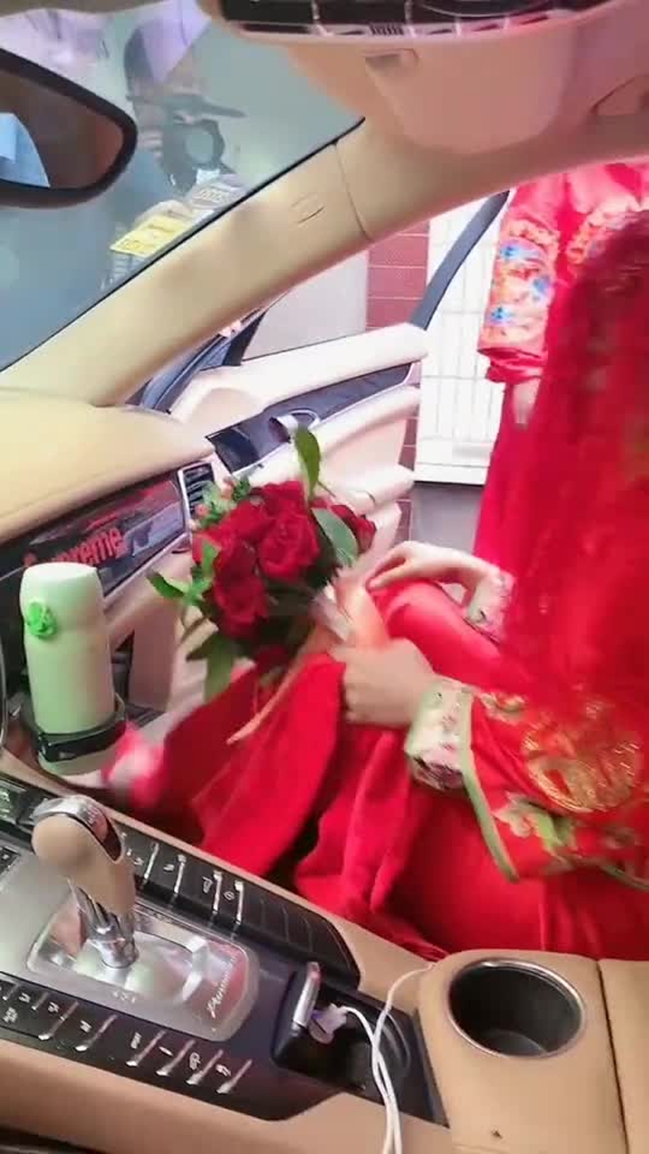 新郎官抱新娘上车,并给新娘穿鞋