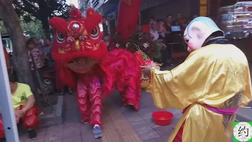 醒狮队为商家开张助兴,大头佛现场挑逗狮子,乡亲们高兴坏了