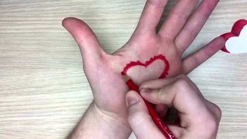 绘画艺术:画家用心形模型在手上画画,红色看起来就非常的亮眼