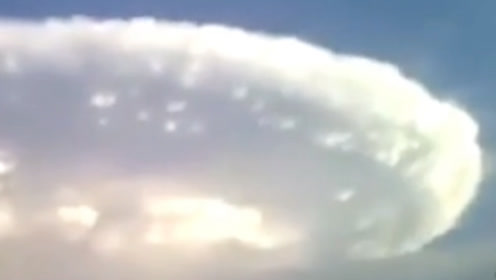 飞碟躲藏在云朵中，看样子UFO体积有三个足球场大
