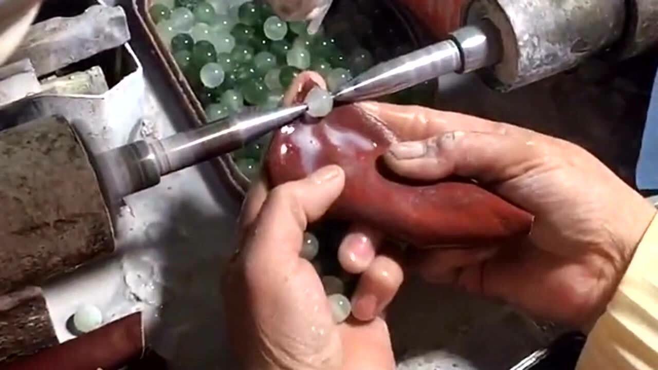 60多岁的奶奶带着老花镜,在手工打磨玉石,阴天下雨的时候手还会很疼!