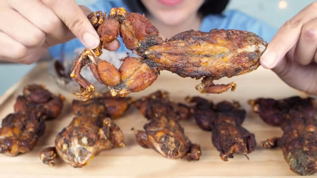 国外的女吃货,拿来几个油炸过后的青蛙,吃起来是又香又脆