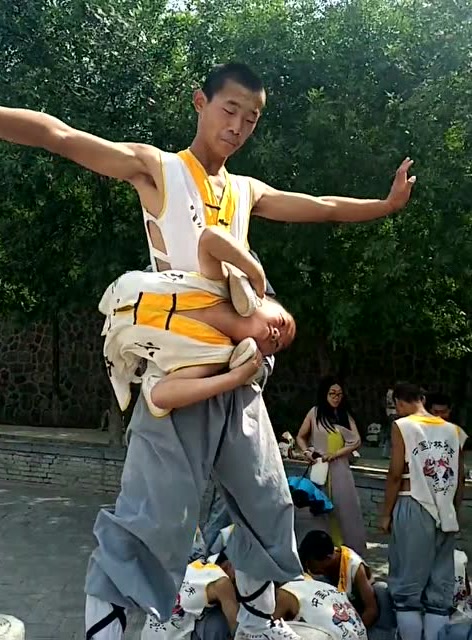 少林寺的孩子太厉害了,能把自己缠绕在一位成年人的腰上