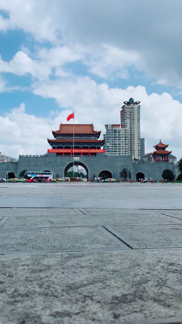 曲靖南城门一座城市的象征国旗飘扬人来人往车水马龙