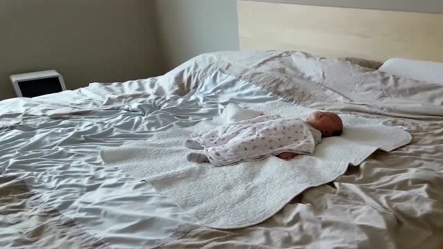 刚出生15天的宝宝,自己在床上睡着了,小模样真是好可爱啊!