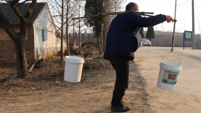 童年记忆中的画面,看烟台农村大叔用扁担挑水的过程