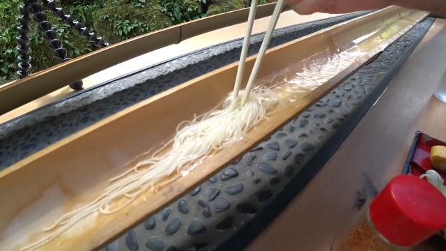 奇特的面条吃法流水素面,采用竹子做滑道,面条从上游流到下游