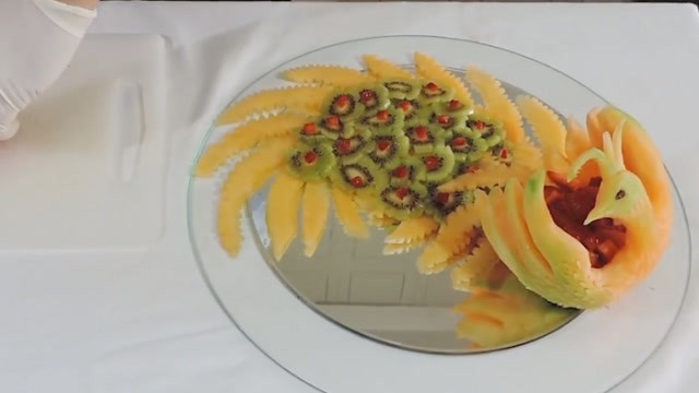 用哈密瓜雕刻的孔雀水果拼盘,做法简单,招待客人再合适不过了