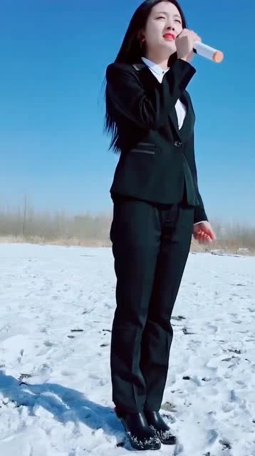 职业装美女,穿着高跟鞋,在雪地里唱没有情人的情人节