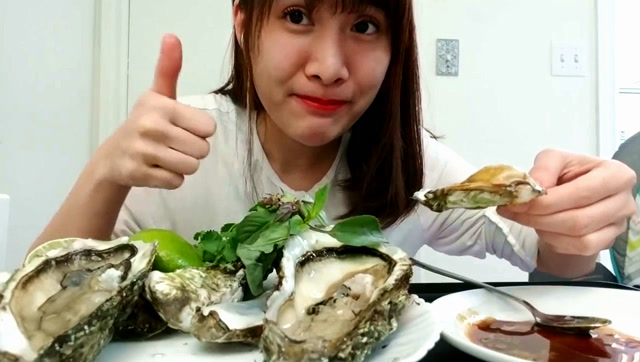 越南美女吃新鲜生蚝,加上青柠,酸得直皱眉