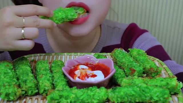 小姐姐吃绿色的炸春卷,吃起来酥酥脆脆,味道超级赞