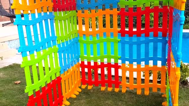 小朋友和爸爸用彩色围栏搭成小屋子