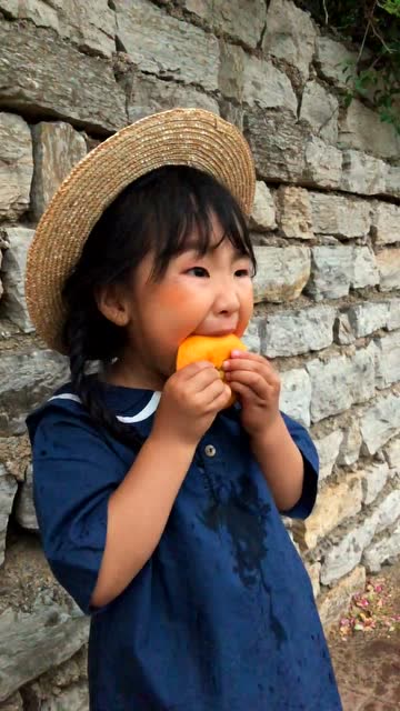 照片拍到一半,小朋友突然吃起了橘子,这也太可爱了吧?