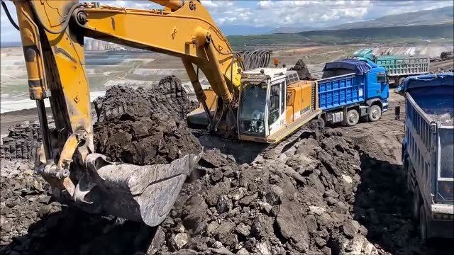 实拍挖掘机挥舞大铲奋力掘土装车