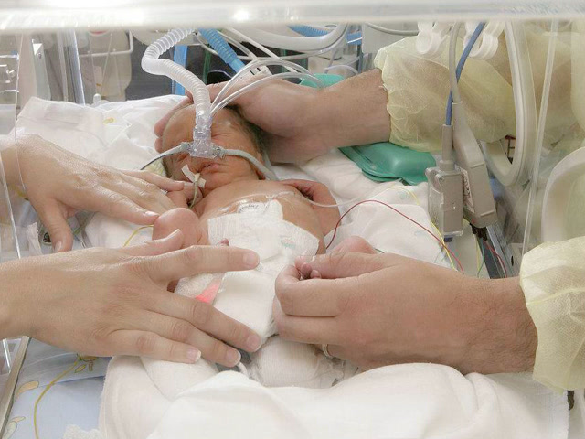 护士隔着保温箱给早产儿宝宝换衣服,这精细活儿一般人干不了!