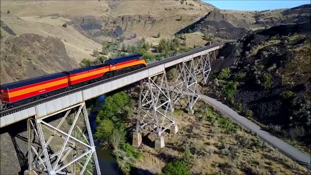 空中拍摄,酷炫的火车头拉着货物在峡谷中穿梭