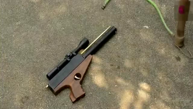 越南小伙先用气筒给枪打满气,然后再进行射击打把