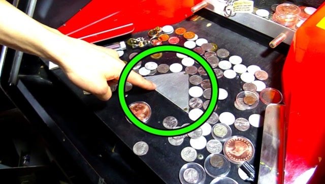 作死小伙对推币机"下手",企图用磁铁将硬币吸出,结果后悔了