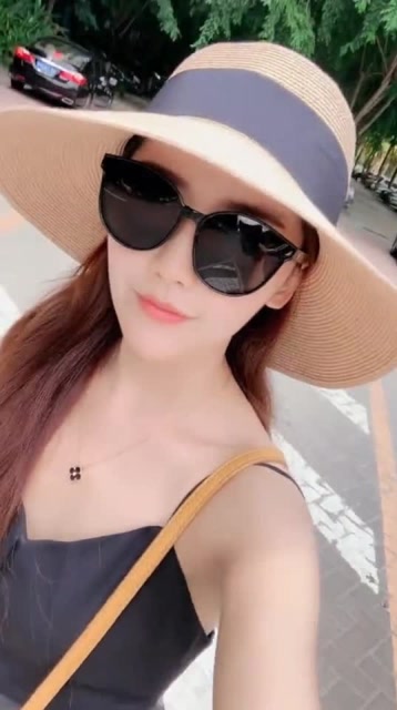 长发气质美女带着墨镜和帽子散步好迷人