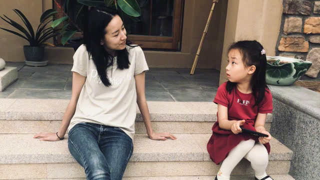 董洁面带微笑轻嗅樱桃 与女儿同坐台阶温馨满满