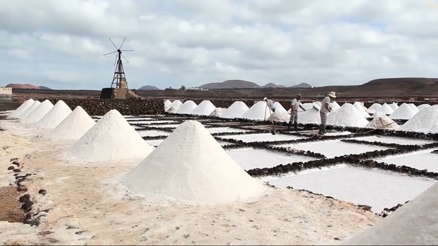从早忙到晚的晒盐场,用古法制粗盐,堆积在那里如小沙丘般