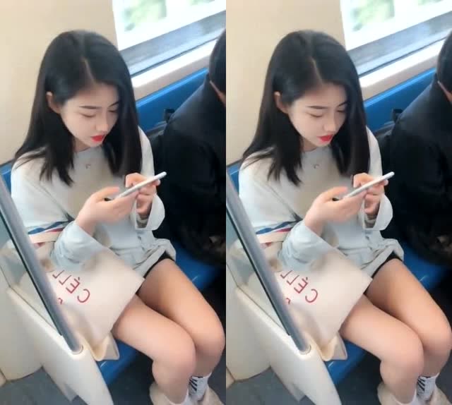 美女坐着地铁,一个人安静地玩手机
