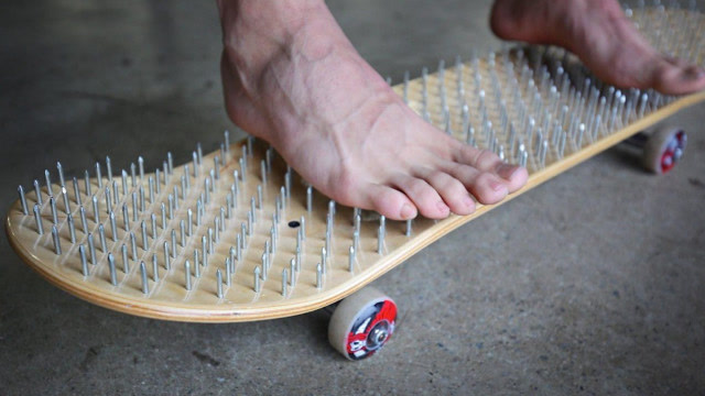 外国小伙在滑板上铺满钉子,光脚踩上去,你猜下场会怎样?