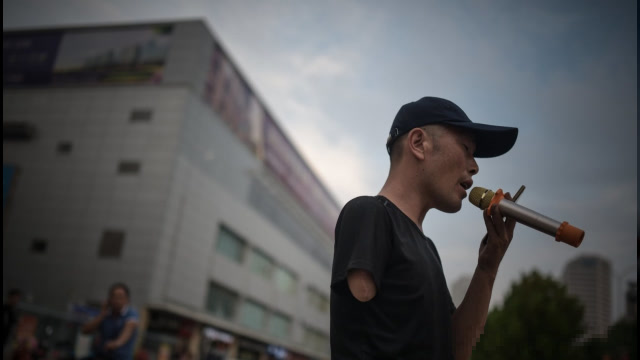 无手无脚父亲上街卖唱乞讨,惨遭同行打骂,伸出手臂时让人同情