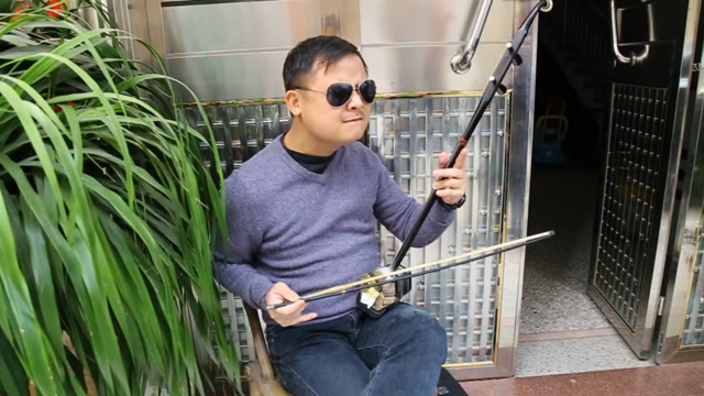 带着墨镜,情不自禁的拉着二胡,来看看这位神秘人有多少岁?