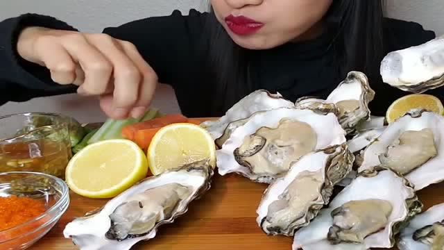 美女吃生蚝,新鲜的生蚝榨点柠檬汁,太美味了!