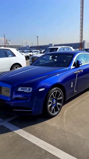 深蓝色的劳斯莱斯魅影在太阳光下显得格外耀眼