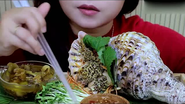 外国小姐姐,吃超大号的海螺,直接切片生吃,q弹有嚼劲
