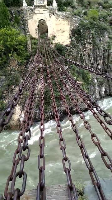当年飞夺泸定桥就是这种铁索,下面波涛汹涌的大河