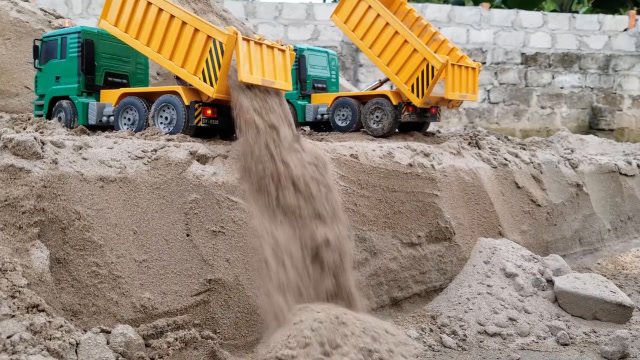 两辆颜色一样的运土机,把车上的泥土,卸在了地下!