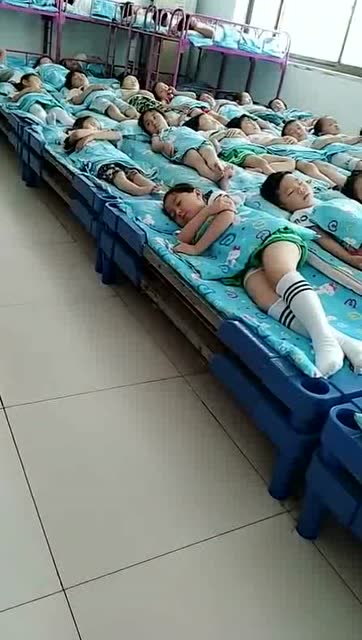 这样的幼儿园孩子睡觉的情景真是有点很意外,连睡觉姿势都一样