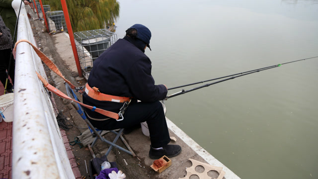 大叔坐桥边钓鱼怕掉河里放大招:一天把自己绑桥上8小时