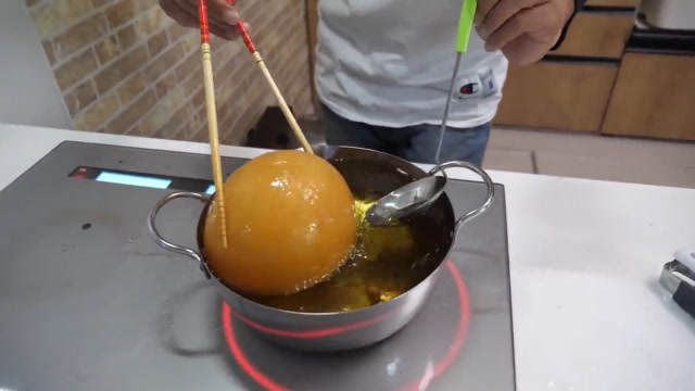 小伙在家玩炸面团,不料碰到油后却越变越大,真是太神奇了