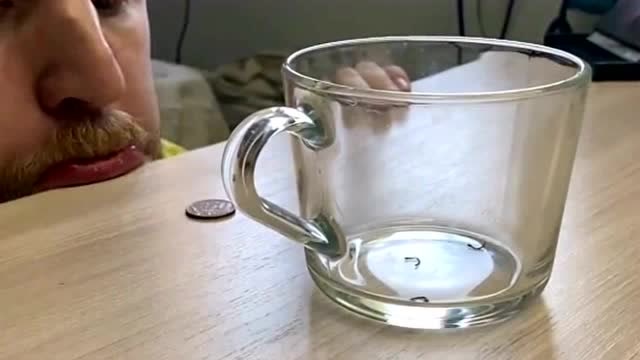 外国小伙在家闲着表演魔术,硬币自己跑到了杯子了,这是什么原理?