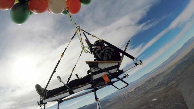 实拍牛人扎了一把氢气球载着自己飞上天,想降落时就一个个打爆!