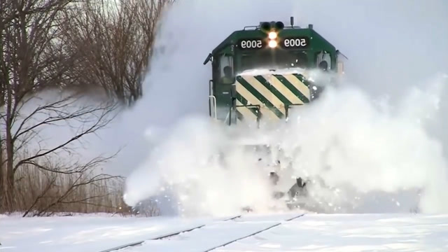 大雪纷飞,挡住了轨道,还好有专业的铲雪车为火车开道