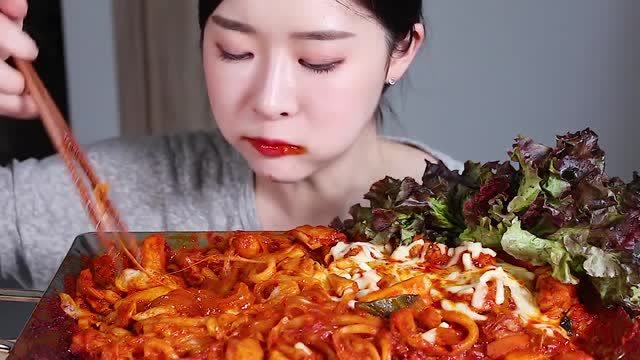 韩国美女吃货,今天又来吃红彤彤的美食,配上蔬菜叶子,吃得真香