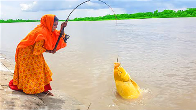 印度大婶江边钓鱼,哇!大鱼上钩了,看看她怎么拉上岸的?